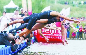 北京國際鐵人三項(xiàng)賽選手在園博湖魚躍入水